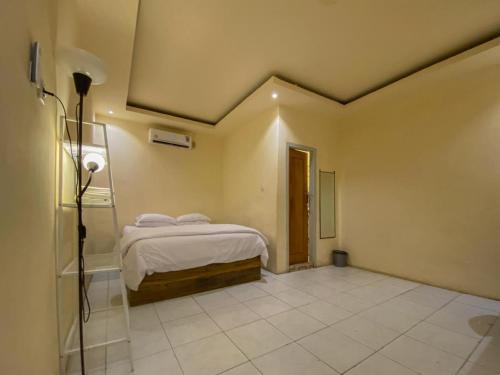 a bedroom with a bed in the corner of a room at Urbanview Hotel ME Jayapura in Jayapura