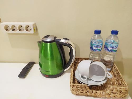 a tea kettle and two bottles of water on a counter at RedDoorz near Prawirotaman Yogyakarta in Yogyakarta
