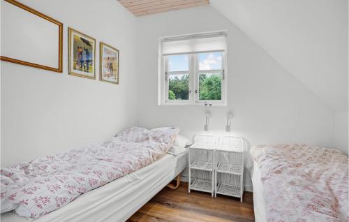 エーベルトフトにあるStunning Home In Ebeltoft With Wifiの白い部屋で、ベッド2台、窓が備わります。