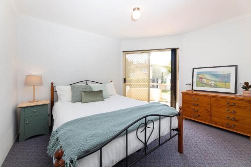 a bedroom with a bed and a dresser and a window at Haven Waters 3 in Forster