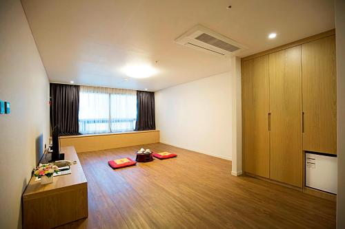an empty living room with a desk and a tv at Best Western Jeju Hotel in Jeju