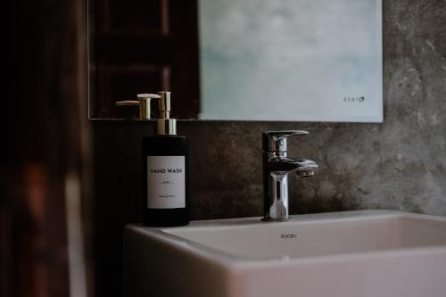 a bottle of soap sitting on top of a sink at Roy's Villa in Sigiriya