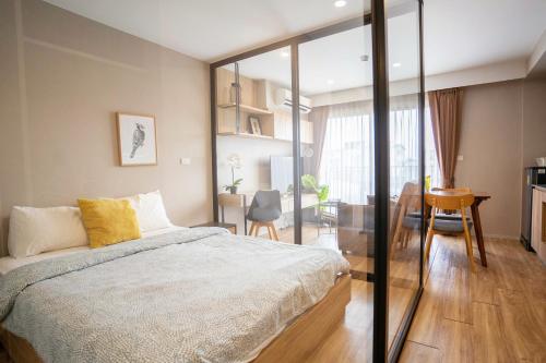 1 dormitorio con 1 cama grande y comedor en 沙吞Blossom Sathon精品公寓 en Bangkok