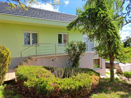 a yellow house with a staircase in a yard at Vlaškovec Experience in Plešivica