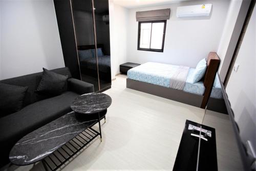 een kleine kamer met een bed en een bank bij VIP Great Hill in Thalang