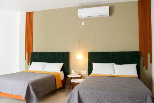 a hotel room with two beds and a lamp at Acacia Hotel in Tuxtla Gutiérrez