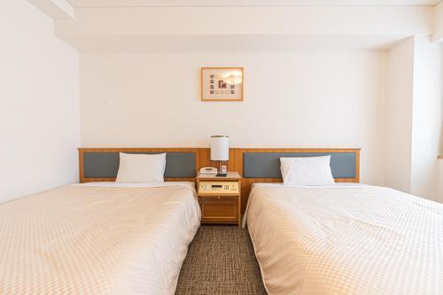 duas camas sentadas uma ao lado da outra num quarto em Forest Hongo by unito em Tóquio