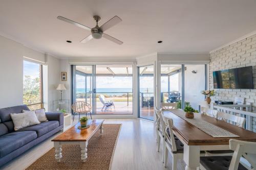 a living room with a blue couch and a table at Port Willunga Ocean Views Beachhouse in Port Willunga