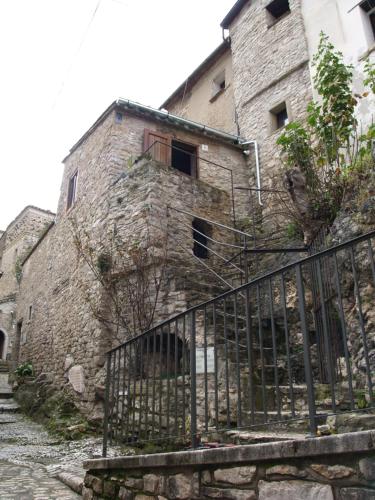 um antigo edifício de pedra com escadas e uma cerca em Dimora Forgione B&B - Pietrelcina em Pietrelcina