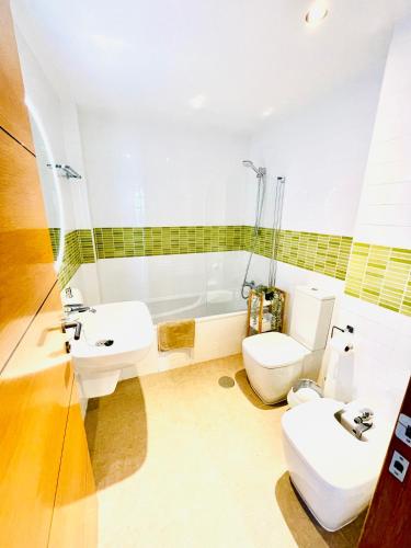 a bathroom with a sink and a toilet and a tub at Apartamento Rokita Blanca in La Manga del Mar Menor