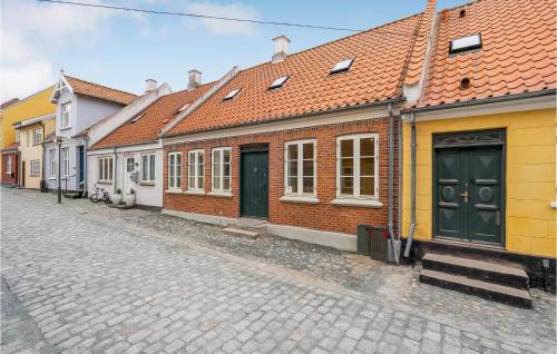 a row of houses on a cobblestone street at Stunning Home In Rudkøbing With Kitchen in Rudkøbing