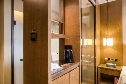 a bathroom with a glass door to a room at Hilmanhomeful Hotel - Caijia Subway Station in Chongqing