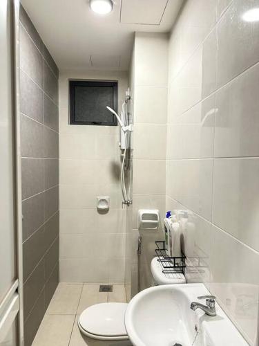 Cozy 2 BR Apartment w/ Pool Gym Wi-Fi & Work Space في كلانغ: حمام مع مرحاض ومغسلة
