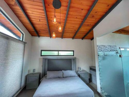 ein Schlafzimmer mit einem Bett und einer Holzdecke in der Unterkunft Chalet 08 in Mazamitla