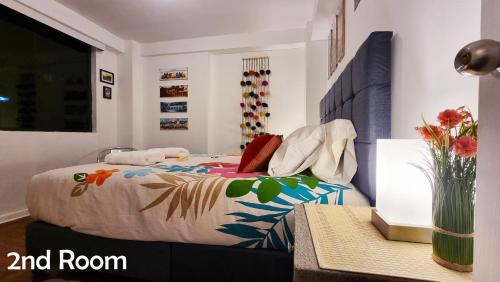 een slaapkamer met een bed met een kleurrijk dekbed bij Amaru Wasi in Cuzco