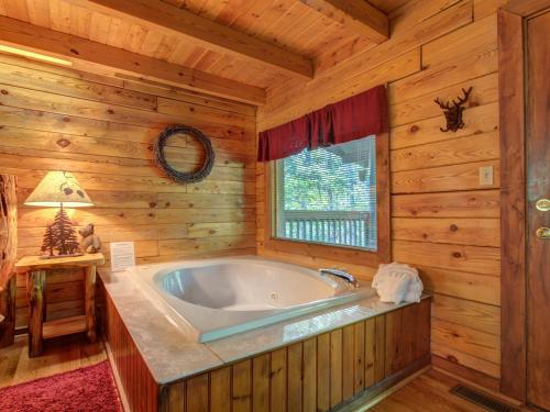 a bathroom with a tub in a log cabin at Buckhorn, 2 Bedrooms, Sleeps 6, WiFi, Jetted Tub, Fireplace, Hot Tub in Gatlinburg
