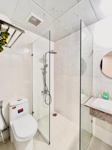 a bathroom with a shower and a toilet and a sink at Tuna Hotel Phú Yên in Liên Trì (3)