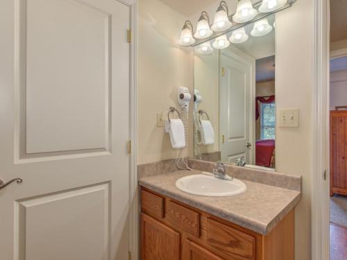 een badkamer met een wastafel en een spiegel bij Riverside Dream Cedar Lodge 103 in Pigeon Forge