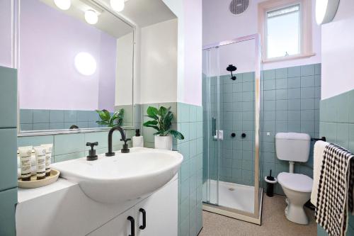 een badkamer met een wastafel en een toilet bij The White House Fitzroy - One of the largest single dwelling accommodations in Melbourne