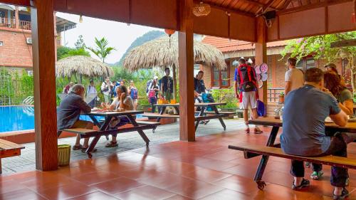 a group of people sitting at tables in a restaurant at Trang An Village Homestay in Ninh Binh