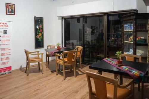 a dining room with wooden tables and chairs at RedDoorz Plus @ Alun Alun Nganjuk in Nganjuk