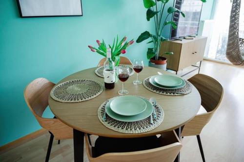 a wooden table with plates and glasses of wine at Boho-Chic-Wohnung Neusiedl in Neusiedl am See