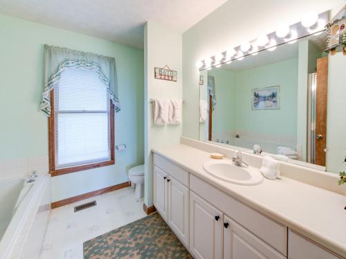 a bathroom with a sink and a mirror at Above and Beyond, 2 Bedrooms, Sleeps 6, Private, Amazing View, Hot Tub in Gatlinburg