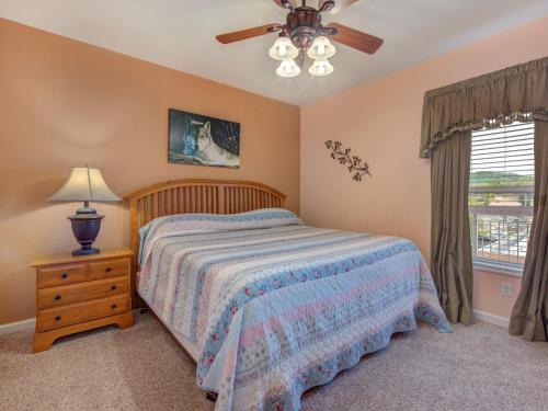 a bedroom with a bed and a ceiling fan at Creekside Hideaway Bear Crossing 403 by VTrips in Pigeon Forge