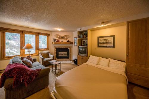 sypialnia z łóżkiem, kanapą i kominkiem w obiekcie Iron Horse Building D Unit 4104 w mieście Winter Park
