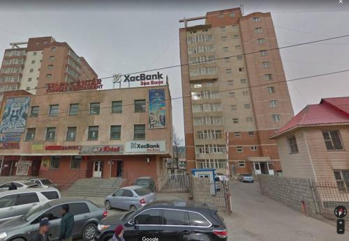 a street with cars parked in front of buildings at OUNT-Central location, spacious, cozy and secure in Ulaanbaatar