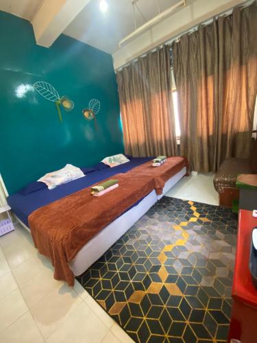 a bedroom with a bed and a blue wall at Pesona Backpackers Inn in Kota Bharu