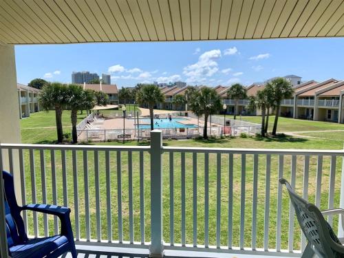 a balcony with a view of a pool and palm trees at 10 H Two Bedroom Condo in Destin