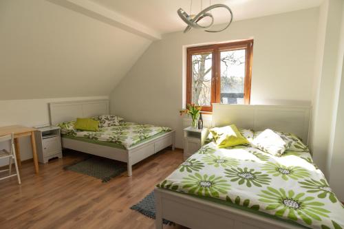 1 dormitorio con 2 camas, escritorio y ventana en DOM POD DĘBAMI, en Gryżyna