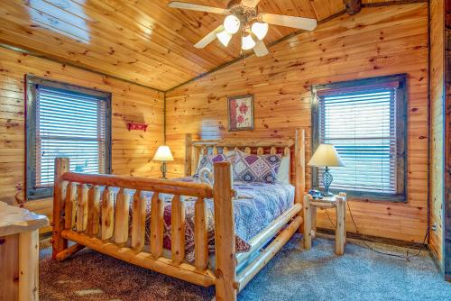 una camera da letto in stile baita di tronchi con letto e ventilatore a soffitto di Standing Bear Lodge, 5 Bedrooms, Sleeps 18, Pool Table, Air Hockey, Hot Tub a Gatlinburg