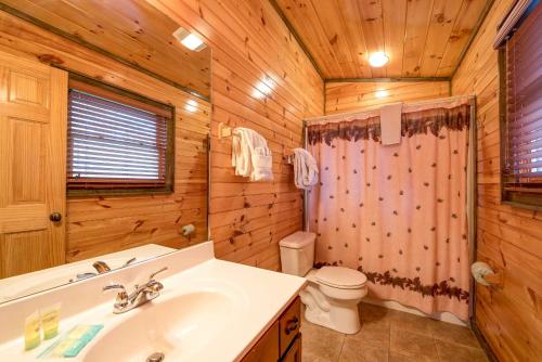 un bagno con lavandino e servizi igienici in una cabina di legno di Standing Bear Lodge, 5 Bedrooms, Sleeps 18, Pool Table, Air Hockey, Hot Tub a Gatlinburg