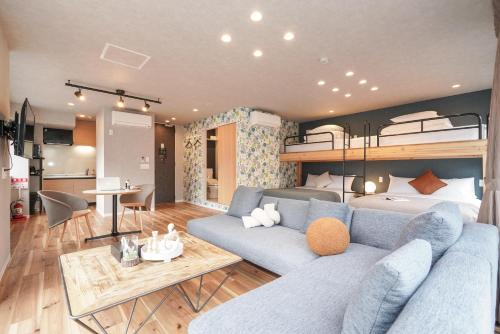a living room with a blue couch and a bunk bed at Tokyo IKOI HOTELー綺麗なホテル in Tokyo
