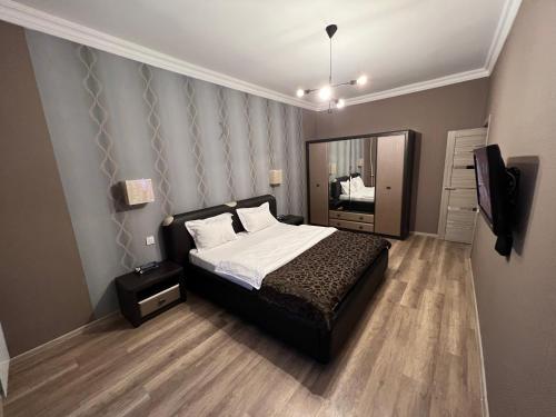 a bedroom with a bed and a television in it at SHAH INN Panoramic Apartments Old City F1 Track Принимаем карты МИР in Baku