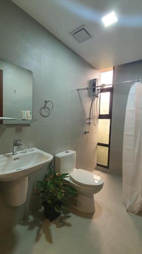 a bathroom with a toilet and a sink at Hotel Mirador in Baguio