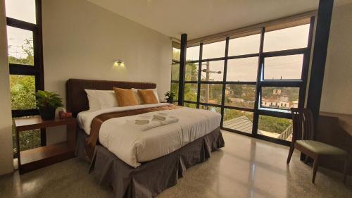 a bedroom with a bed and a large window at Hotel Mirador in Baguio