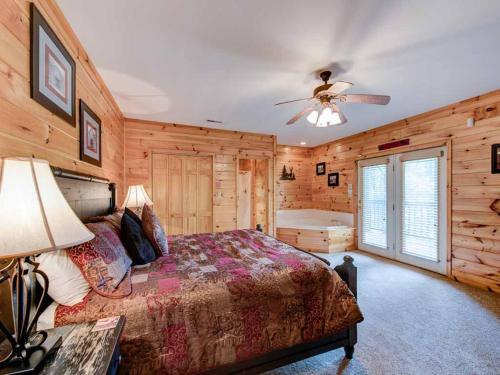 1 dormitorio con 1 cama y ventilador de techo en Our Mountain Getaway, 3 Bedrooms, Sleeps 12, Hot Tub, 2 Jacuzzis, WiFi en Sevierville
