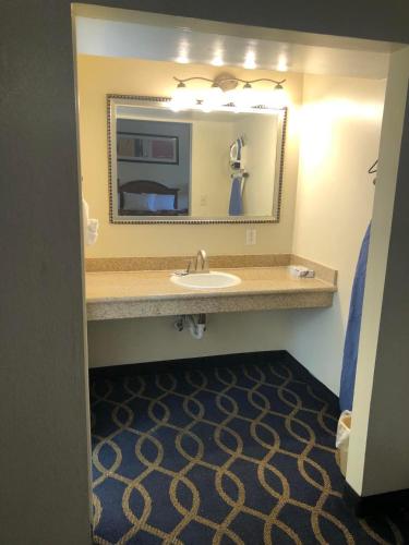 a bathroom with a sink and a mirror at Holiday Motel Oakdale in Oakdale