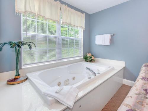 een badkamer met een wit bad en een raam bij Smoky Bear 1103 in Pigeon Forge