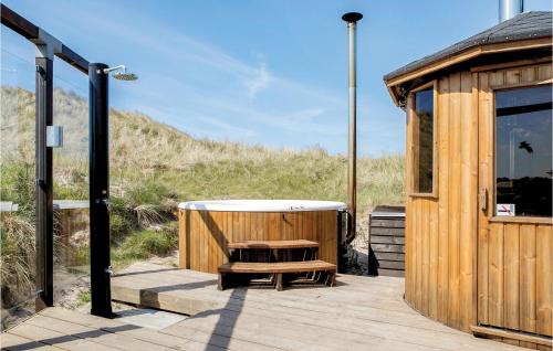 a wooden deck with a bath tub next to a building at Studio Holiday Home In Lokken in Løkken