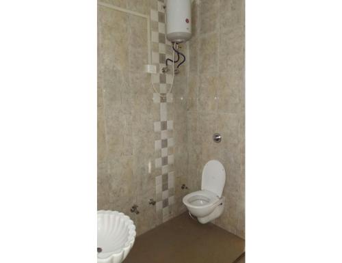 a bathroom with a toilet and a sink at Hotel Agrawal, Pachmarhi in Pachmarhī