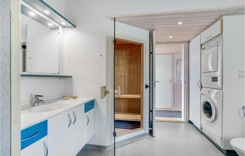 a bathroom with a sink and a washing machine at Holiday Home Blåbærstien Fjerritslev Iii in Torup Strand