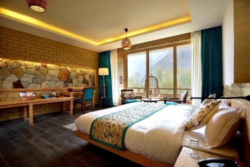 a hotel room with a bed and a desk and a window at Stone Hedge Hotel in Nubra