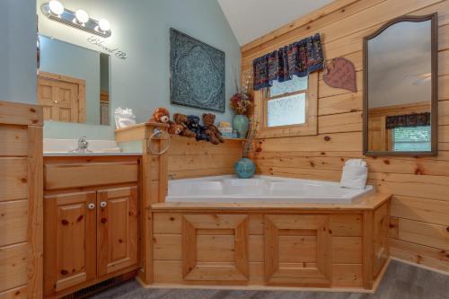 a bathroom with a large tub and a sink at Americana, 2 Bedrooms, Sleeps 6, View, Pool Access, Hot Tub, Fireplace in Gatlinburg
