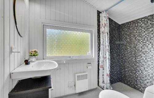 La salle de bains est pourvue d'un lavabo et d'une fenêtre. dans l'établissement Amazing Home In Herning With 4 Bedrooms And Wifi, à Kølkær