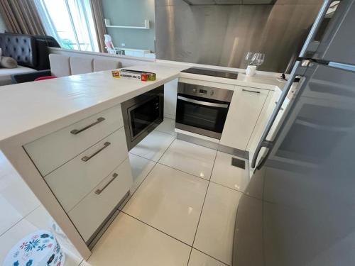 a kitchen with white cabinets and a refrigerator at Kuala Lumpur near KLCC Soho Suite in Kuala Lumpur