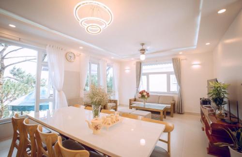 a living room with a white table and chairs at Villa Đà Lạt View Thông in Khu Chi Lăng